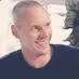 Smiling middle-aged man with short gray hair wearing a black shirt.